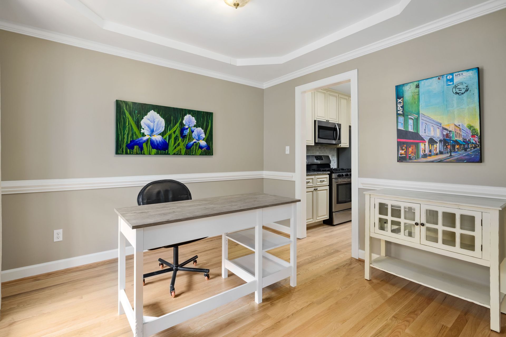 Stylish home office featuring minimalist furniture and vibrant wall art in neutral tones.